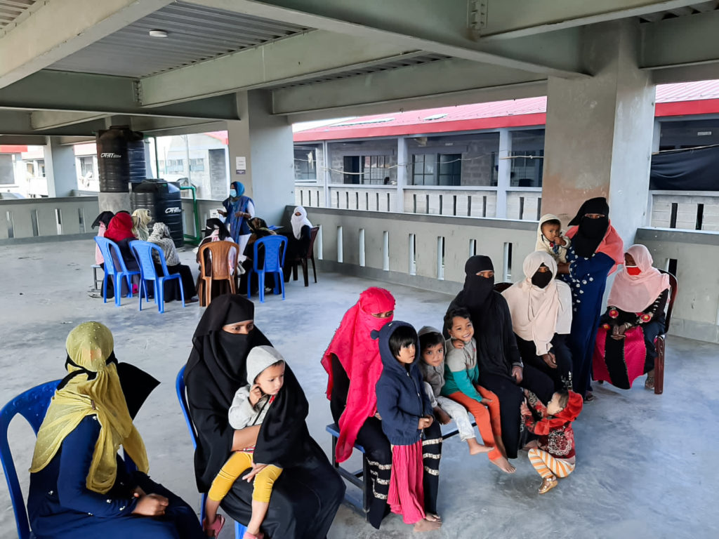 Rohingya women and children waiting at a primary health clinic in Bhashan Char