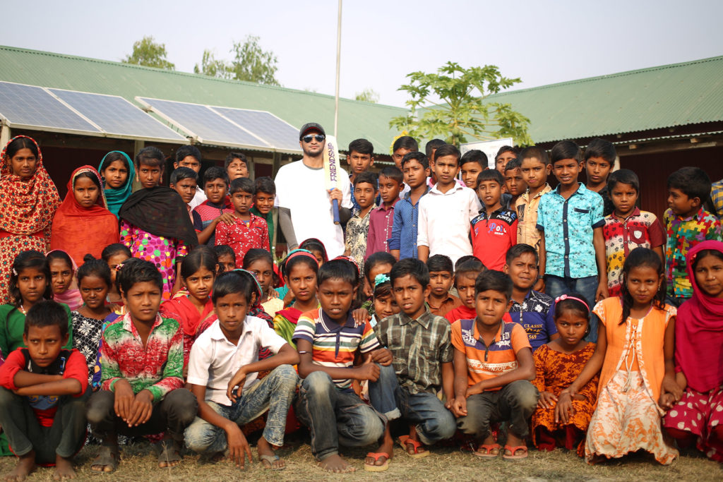 Shakin Al Hasan standing with children from a Friendship school