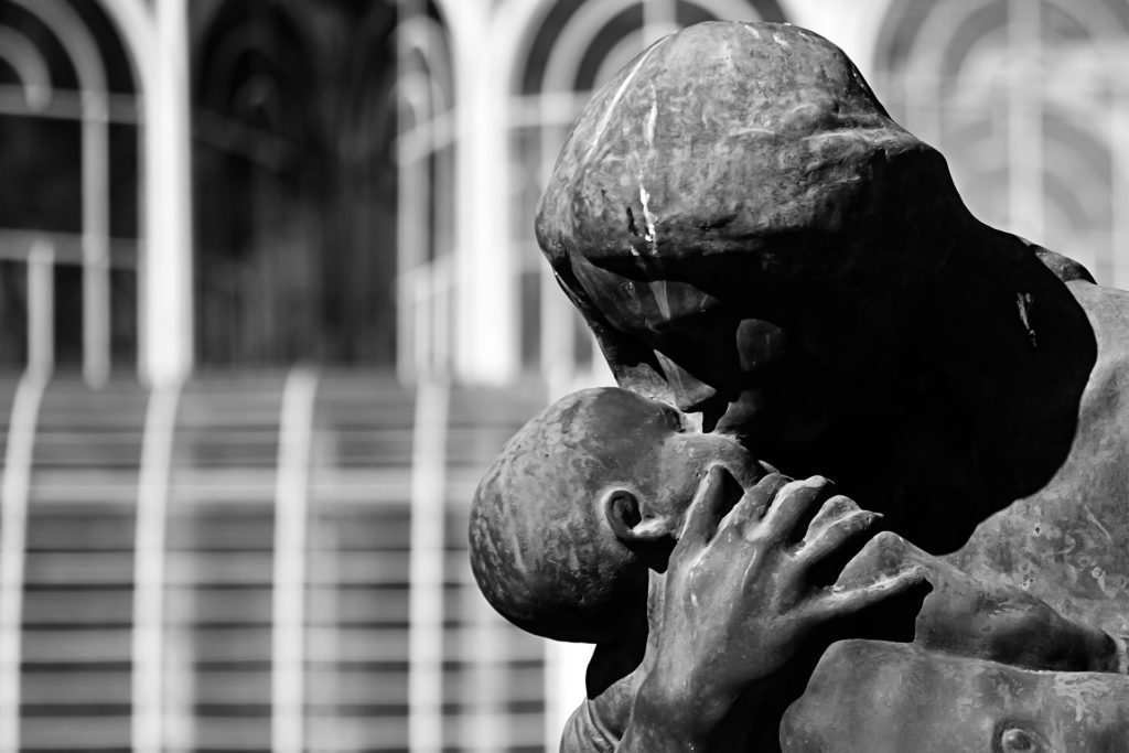 Black and white photo of statue of a mother kissing her baby, used for an article on mother's day