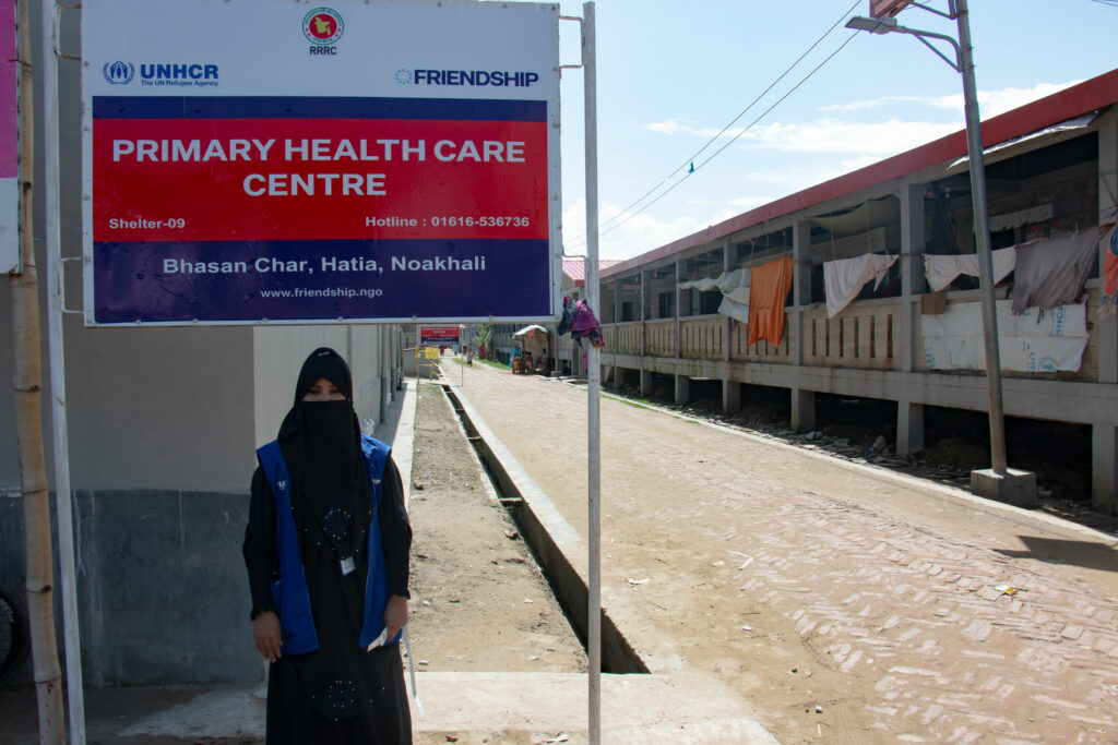 Ayesha Akhter, Friendship medic-aide, standing in front of Friendship Primary Healthcare Centre offering maternal health services in Bhasan Char